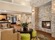 Soft Seating Around Fireplace in Lobby Lounge Area With View of Front Desk and Snack Shop