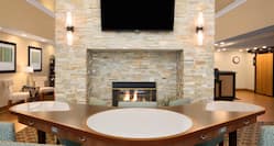V-Shaped Table by Fireplace, Chairs and TV in Lobby Lounge Area
