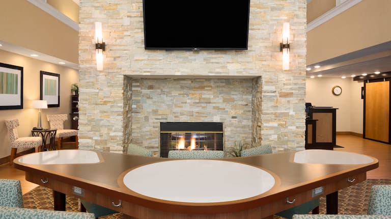 V-Shaped Table by Fireplace, Chairs and TV in Lobby Lounge Area