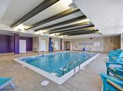 Indoor Swimming Pool With Water Fountain, Towel Station, Chairs, Loungers, and Windows