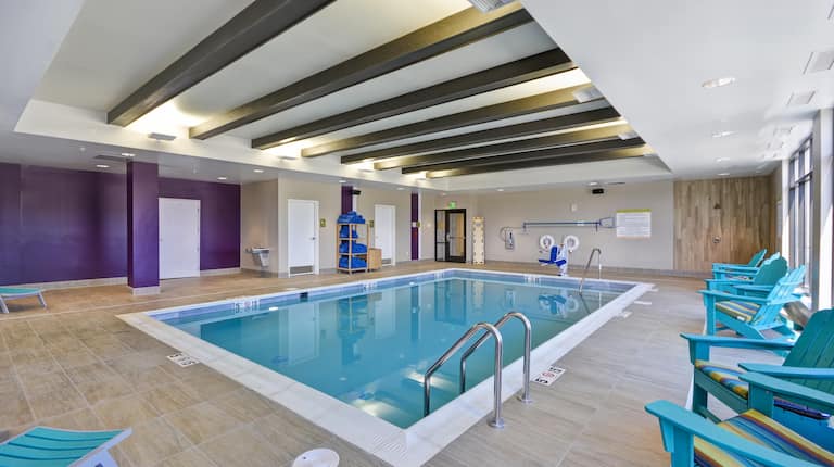 Indoor Swimming Pool With Water Fountain, Towel Station, Chairs, Loungers, and Windows