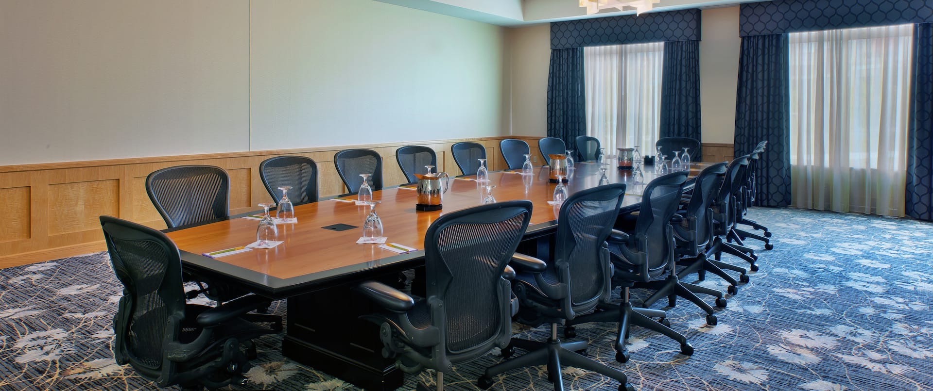 Windows With Long Drapes and Ergonomic Chairs at Table in Ariel Boardroom