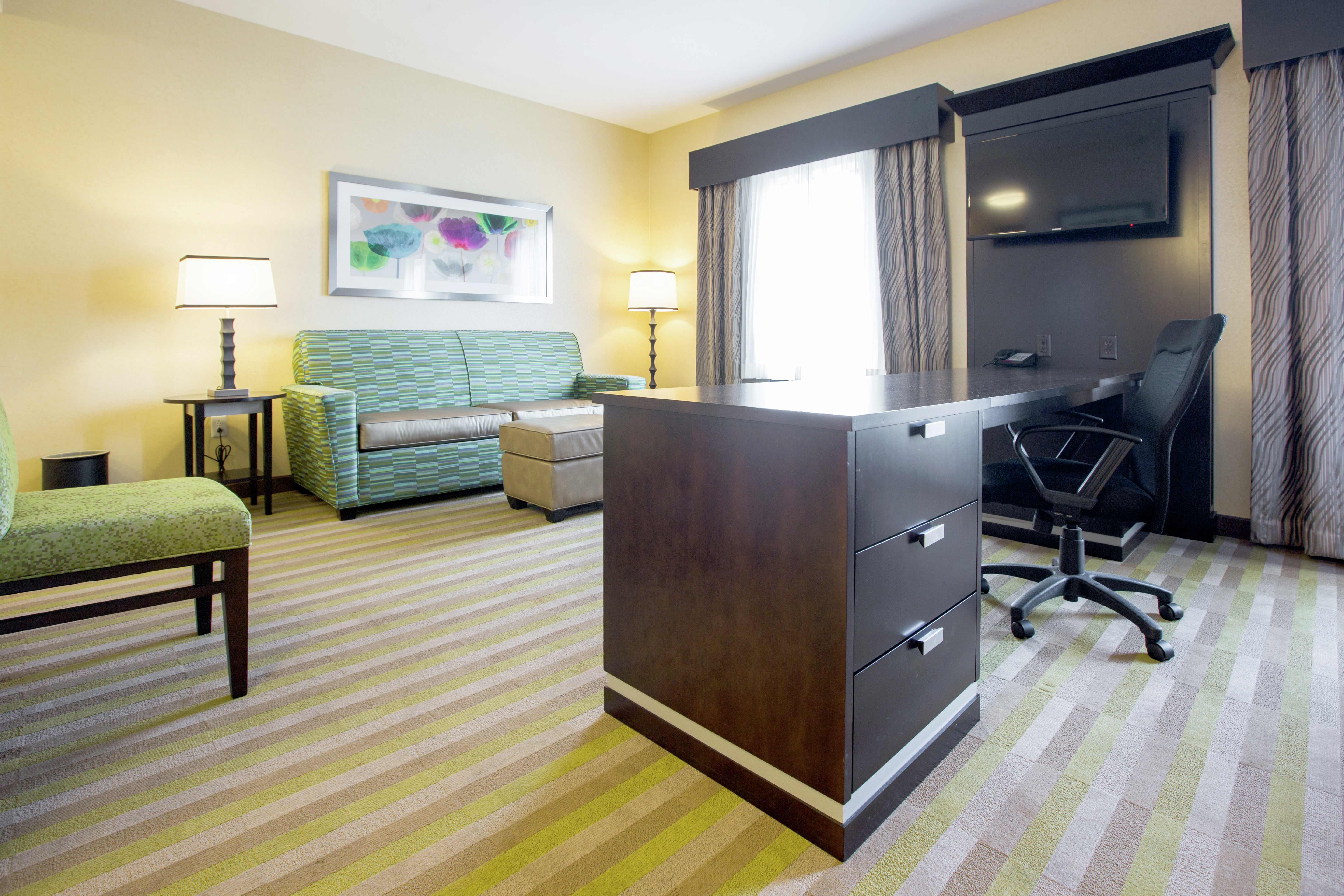Work Desk, Flat Screen TV and Seating Area in a Hotel Suite