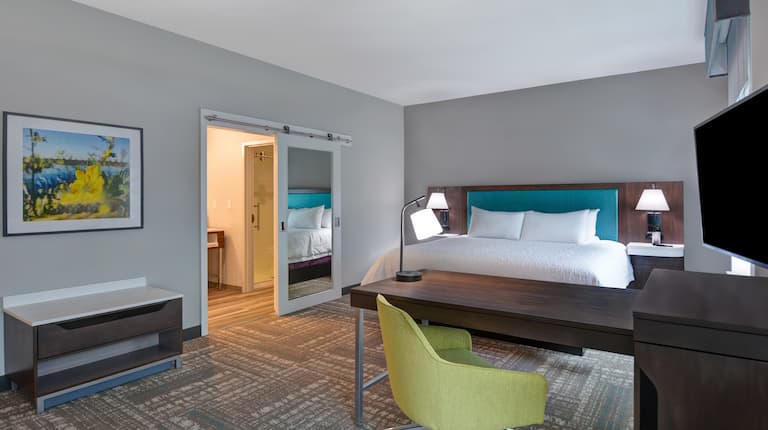 guest room with bed work desk and television