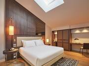 a bed in a room with vaulted ceiling and a skylight