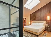 a bed in a room with a vaulted ceiling and skylight
