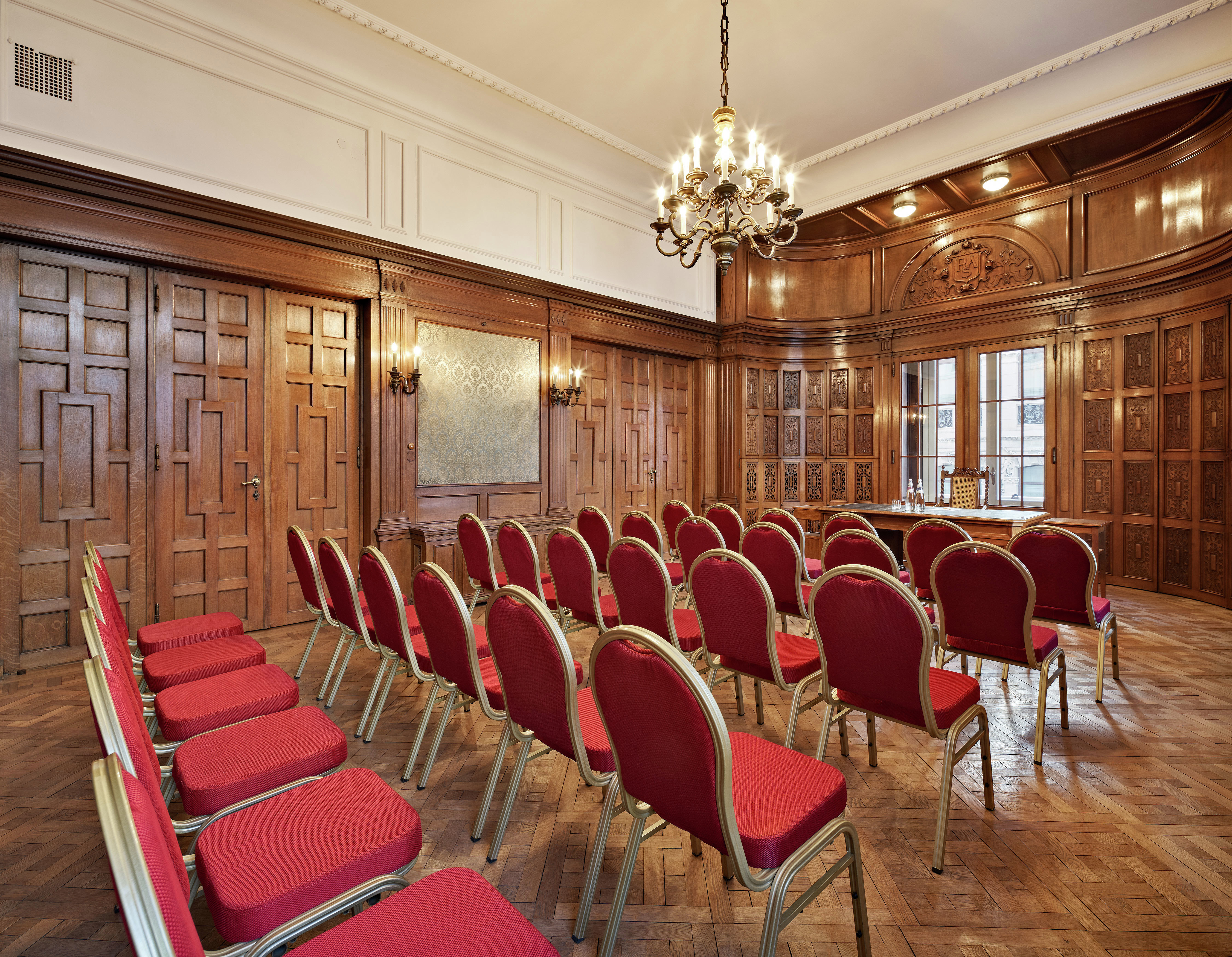 a meeting room with rows of chairs facing a table