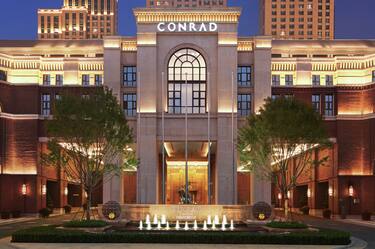 Night view of Conrad Tianjin Hotel with Trees in Front