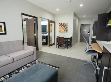  Living Area With Dining Table, Kitchen, Work Desk, and Soft Seating in Studio Suite