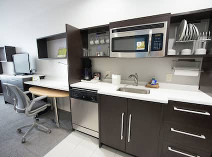 View of TV, Work Desk, and Kitchen in Studio Suite
