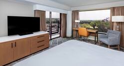 king bedroom with tv, work desk and view of city