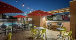 Outdoor Patio Area with Umbrellas, Tables, Chairs and BBQ Grills at Night