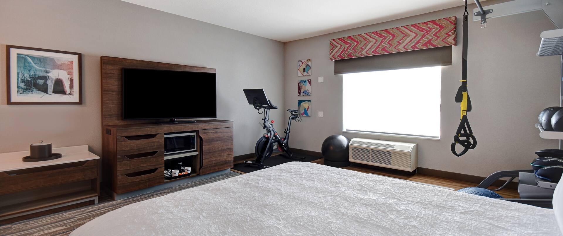 guest room with bed television and fitness center