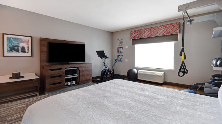 guest room with bed television and fitness center
