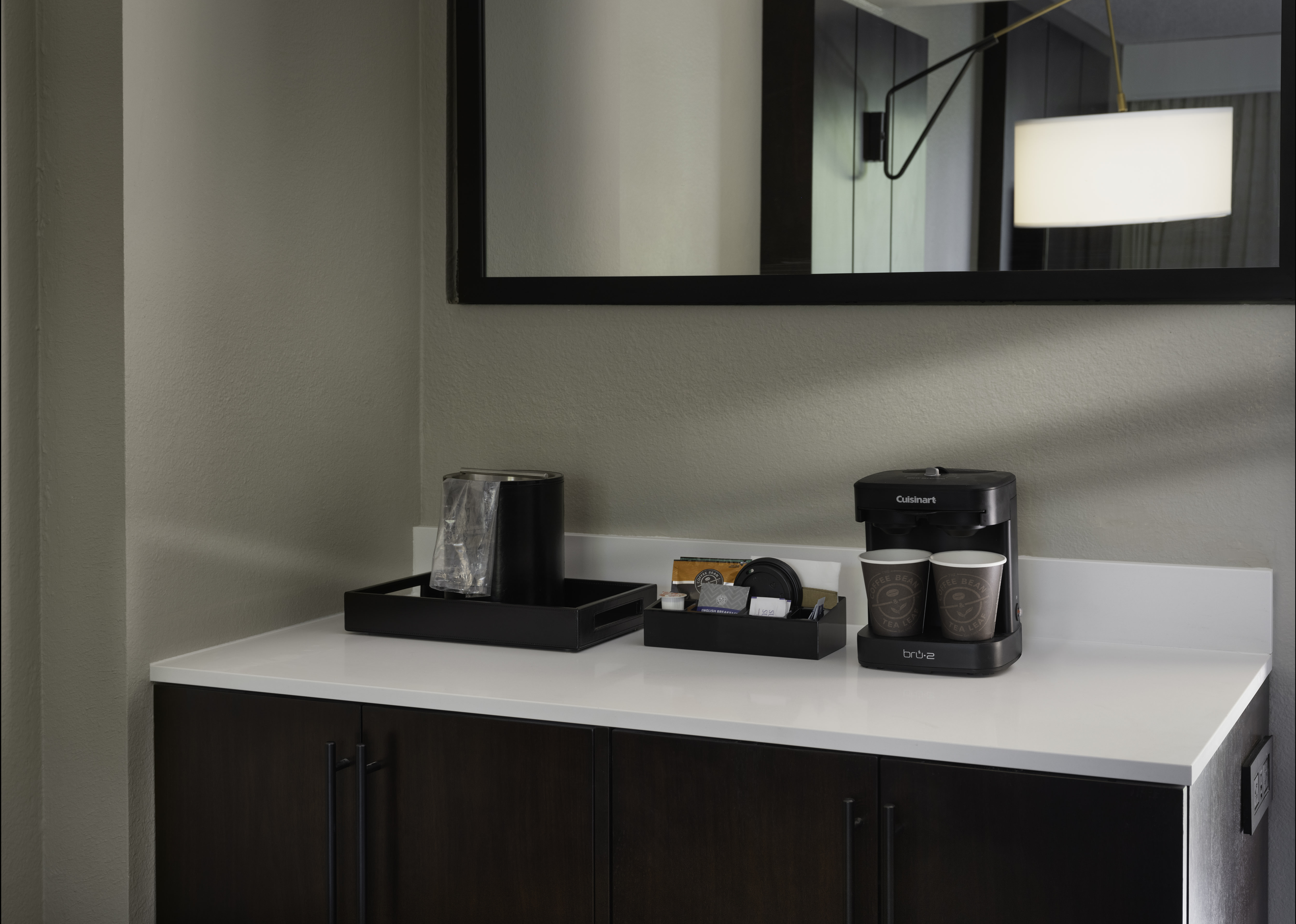 Coffeemaker on credenza with mirror in hotel guest room