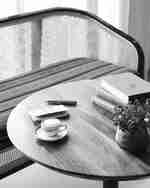 Konferenční stolek s knihami, šálkem a vázou květin