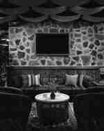 Obývací pokoj s kamennou stěnou a gaučem, pohodlným a příjemným interiérem