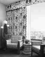 Útulný pokoj s oknem, dvěma židlemi a výhledem na venkovní prostředí