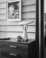 Výzdoba ložnice s dřevěným šatníkem, lampou a nástěnným uměním