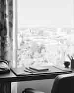  Pracovní stůl a židle před oknem s výhledem na panorama města