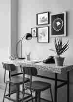  Pracovní stůl s červenými židlemi a rám na fotografii na zdi