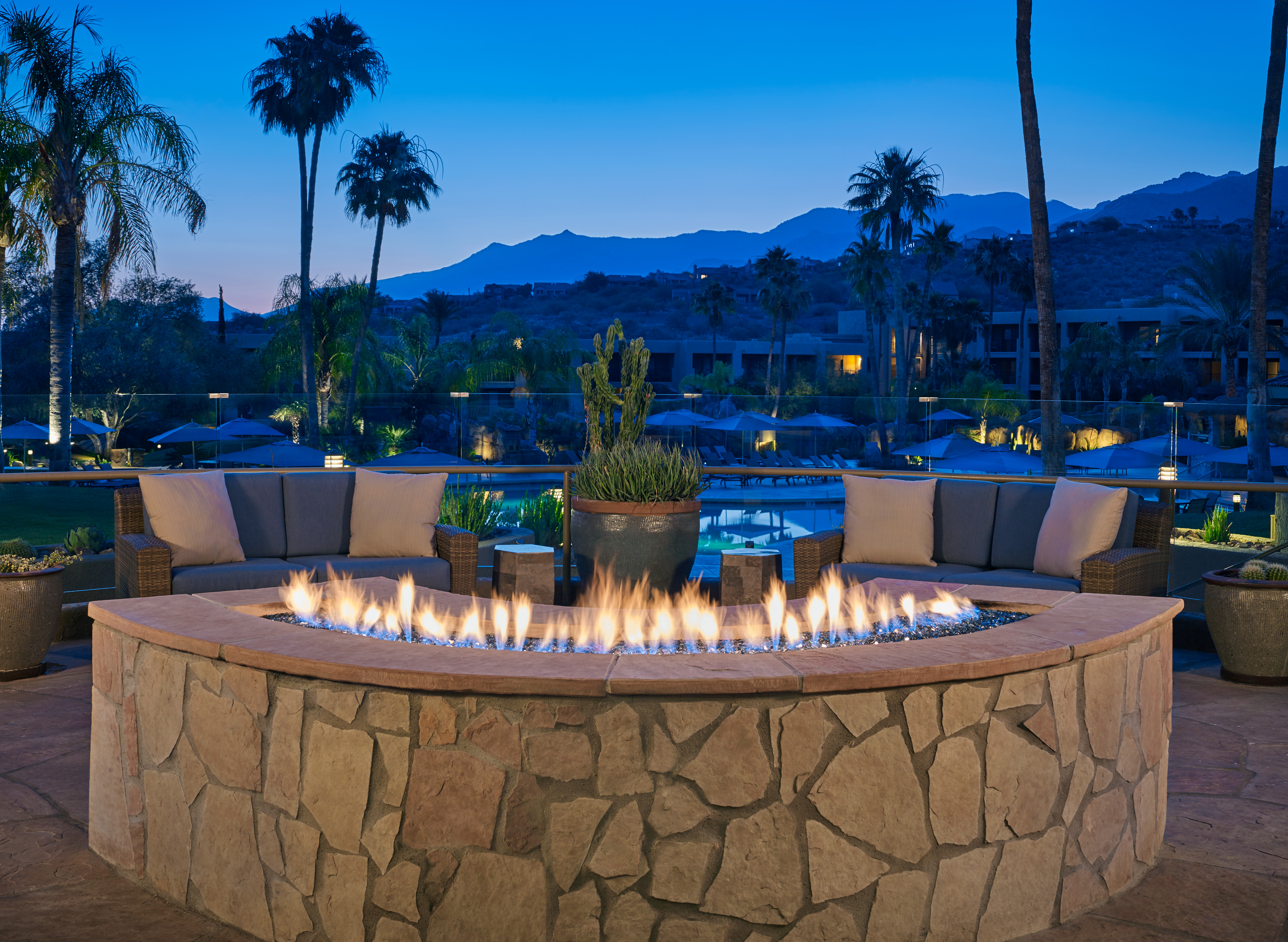 Sunset View of Firepit on Patio with Lounge Chairs and Mountains in the Background