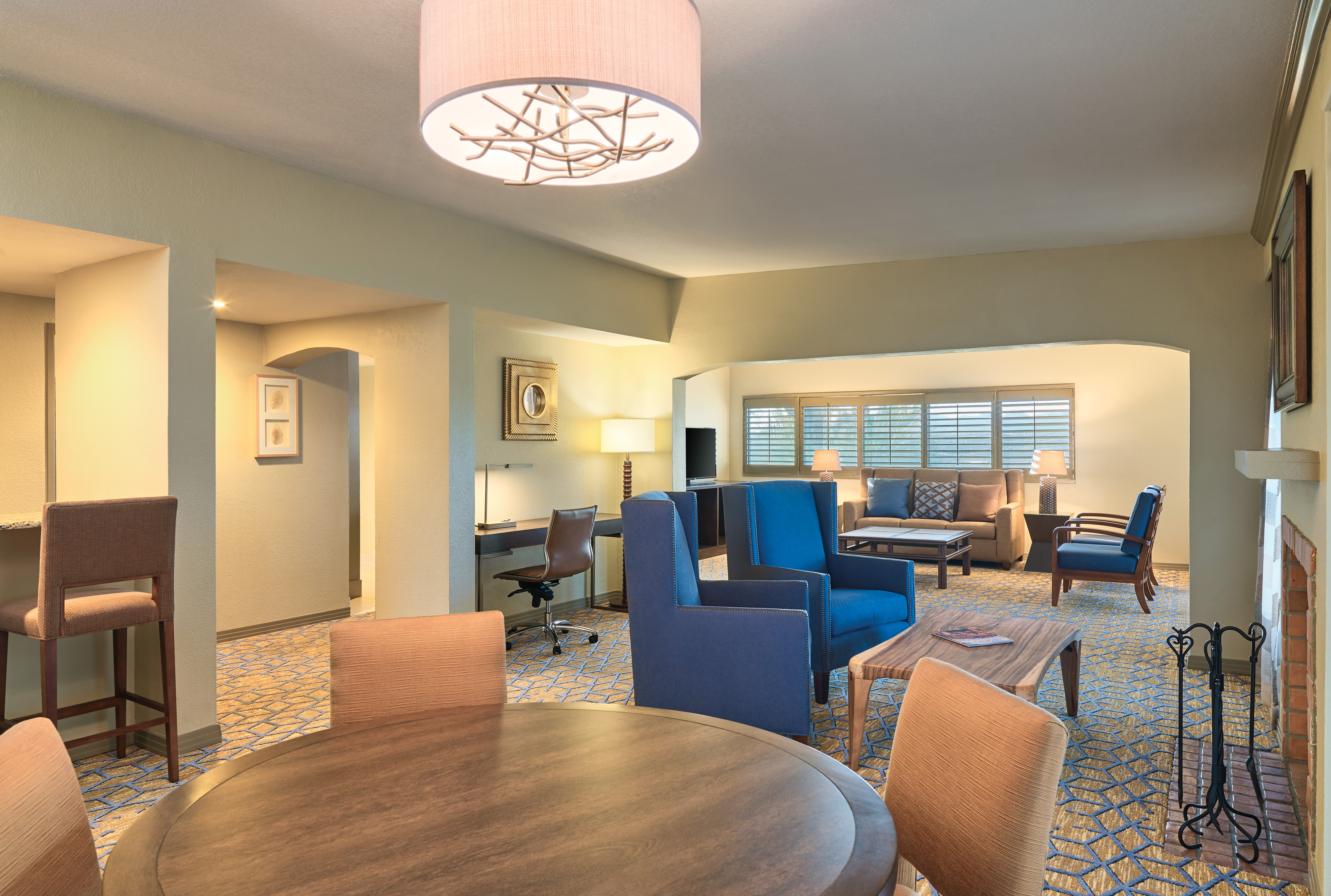 Hospitality Suite Living Area with  Round Table, Chairs, Fireplace, Soft Seating, Sofa and Work Desk