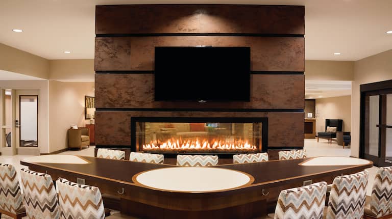 V-Shaped Table With Chairs and TV by Fireplace in Lodge Area