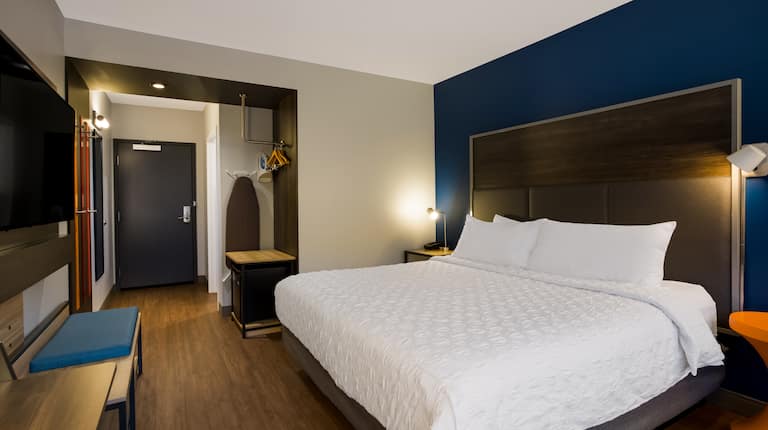 Bed in room with wall-mounted TV