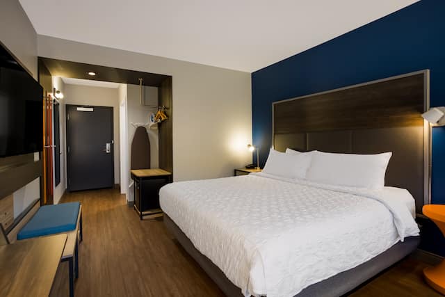 Bed in room with wall-mounted TV