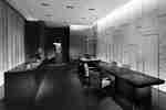 Lounge hotel atau area bersantap dengan meja panjang, kursi, laptop, dan tanaman dekoratif