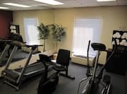 Fitness Center With Mirrored Wall, Window, Elliptical, Treadmill, Bike, and Towel Station