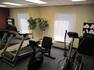 Fitness Center With Mirrored Wall, Window, Elliptical, Treadmill, Bike, and Towel Station