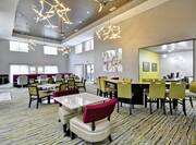Booth, Table, and Bar Seating Options in Dining Area With Ceiling Fans, Decorative Lighting, Wall Art and Windows