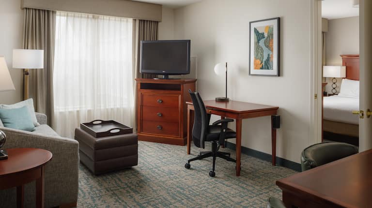 Desk, Living Area and Partial View of Bedroom in a Hotel Suite