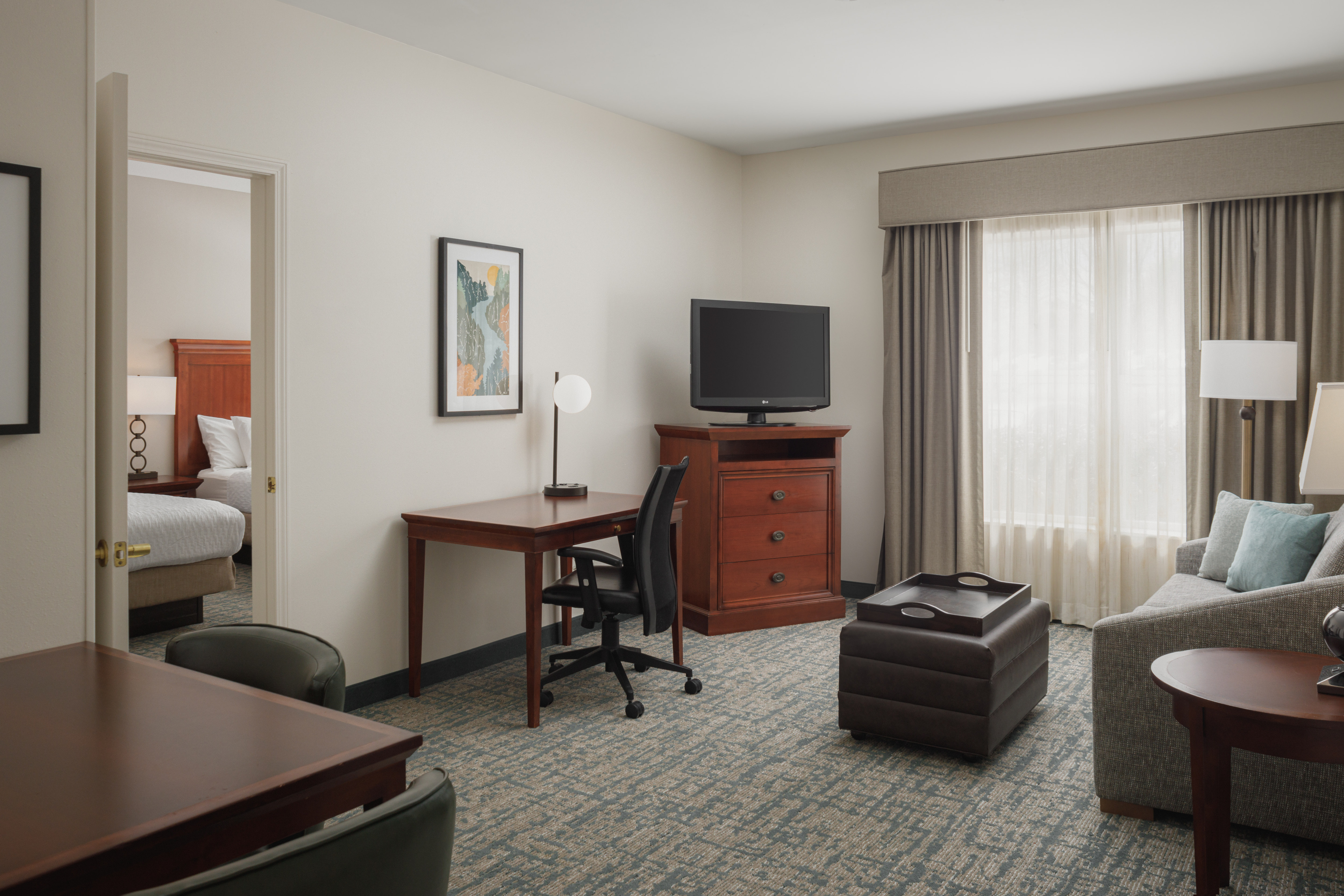 Living Area and Partial View of Bedroom in a Suite with Two Beds