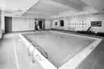 Indoor pool with chairs and handrail