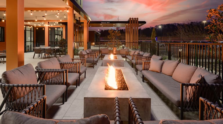 Patio Area at Sunset with Sofas Around Two Fire Pits