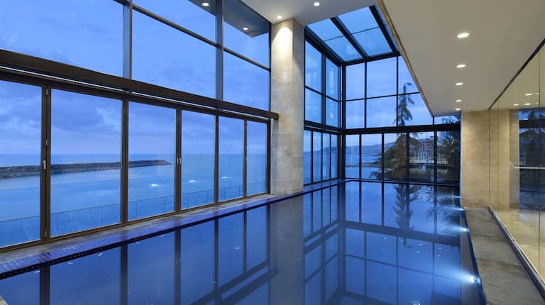 Indoor Swimming Pool with Large Windows Offering Sea View