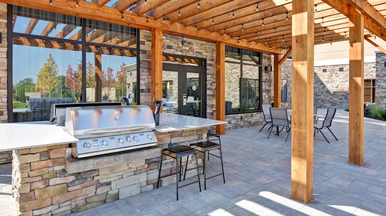 Outdoor patio area with BBQ grill station under pavilion