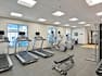 Fitness center with exercise machines, free weights, and windows