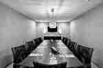 Executive boardroom with long table, chairs, and TV