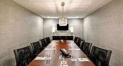 Executive boardroom with long table, chairs, and TV