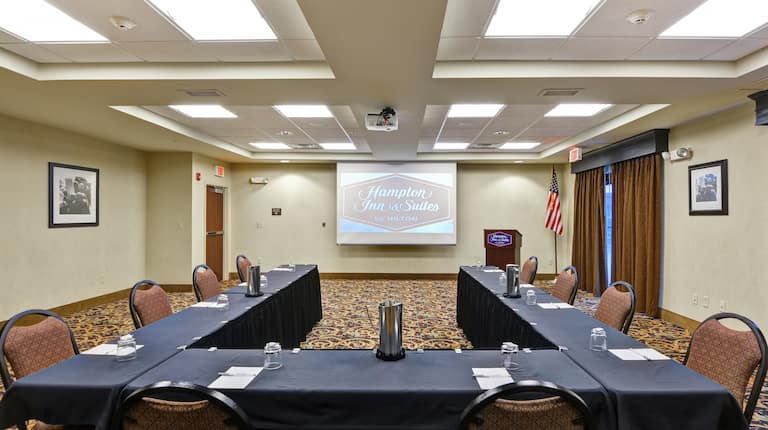 Chairs, U-Shaped Table, Lectern, and Projector Screen in Meeting Room