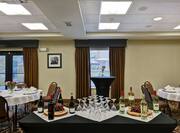 Display of Wine and Wine Glasses on Table Near Banquet and Cocktail Tables in Meeting Room