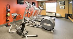Fitness Center With Weight Balls, Cardio Equipment, TVs, Wall Art, Window, and Mirrored Wall
