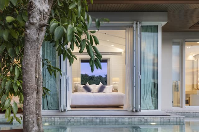 View over private pool to bedroom with king size bed