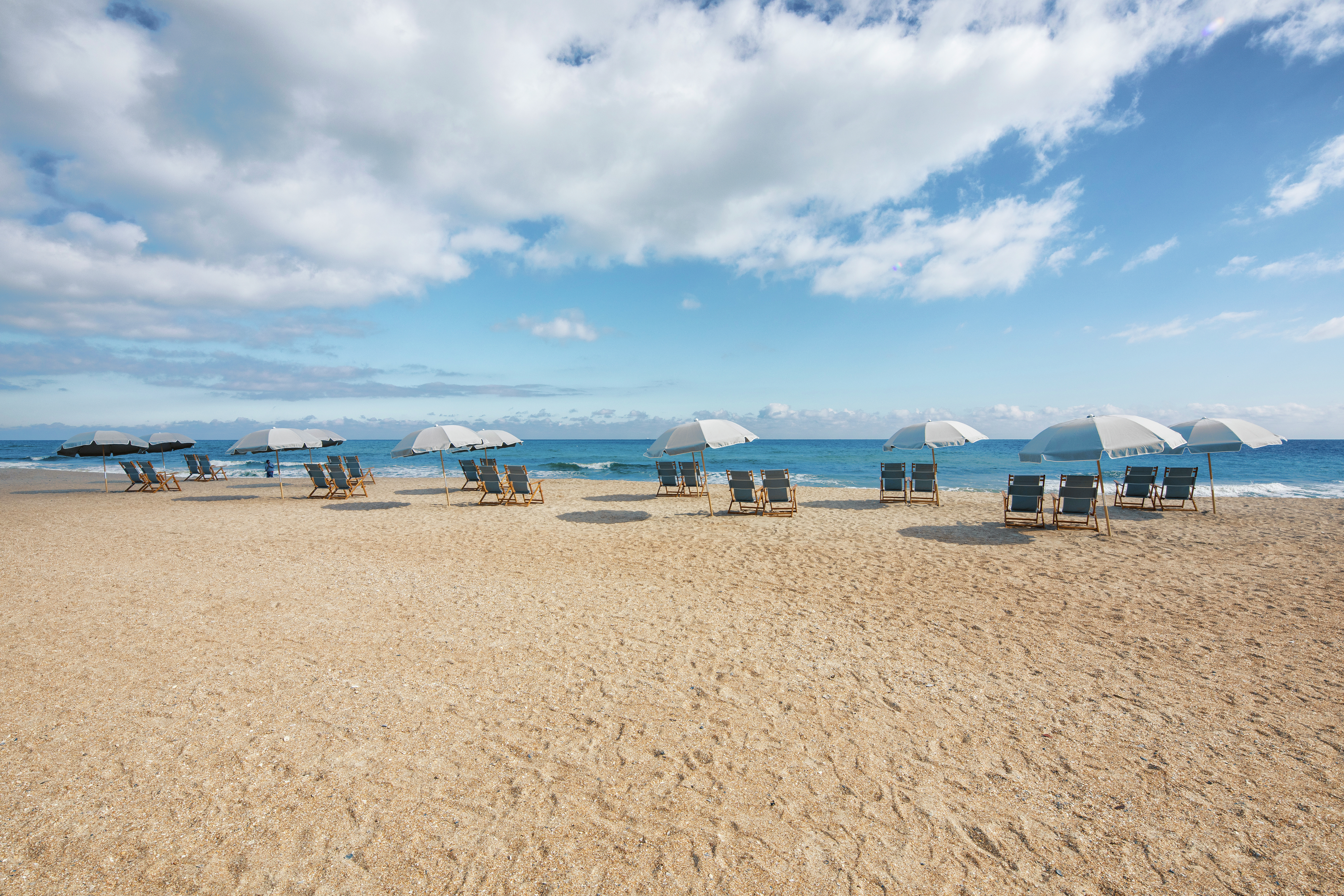 Ocean View, Sun Umbrellas, and Chairs Set Up on Beach 