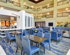 Lobby Dining area with tables, chairs, and TV with view of multiple floors