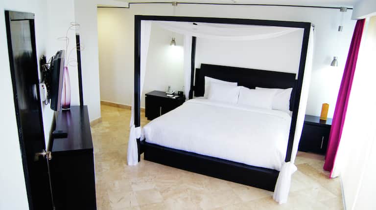 Dormitorio de la suite de un dormitorio con una cama King y balcón